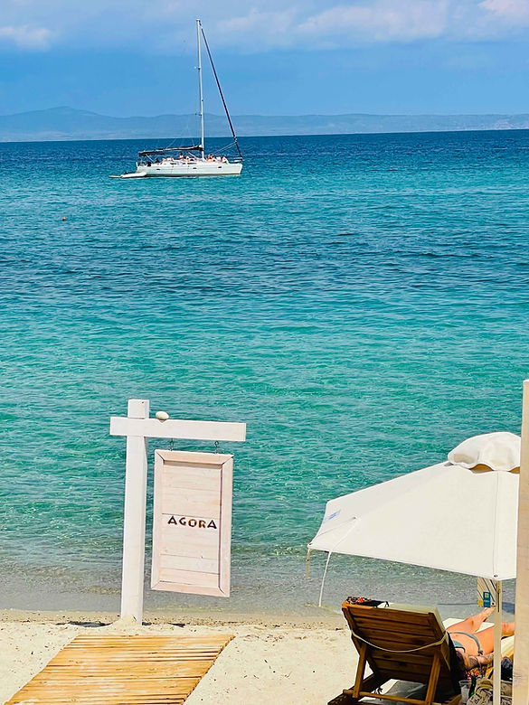 Agora-Beach-Girl-Relaxing-with-Sign.jpg