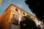 Travel street photography in Seville Spain of yellow building with sun and greenery