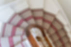 Property photography showing details of spiral stairs with stair runner