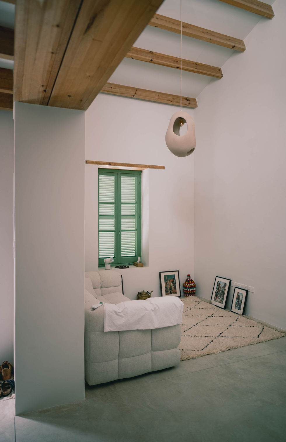 Minimalist room with green window and wooden ceiling.