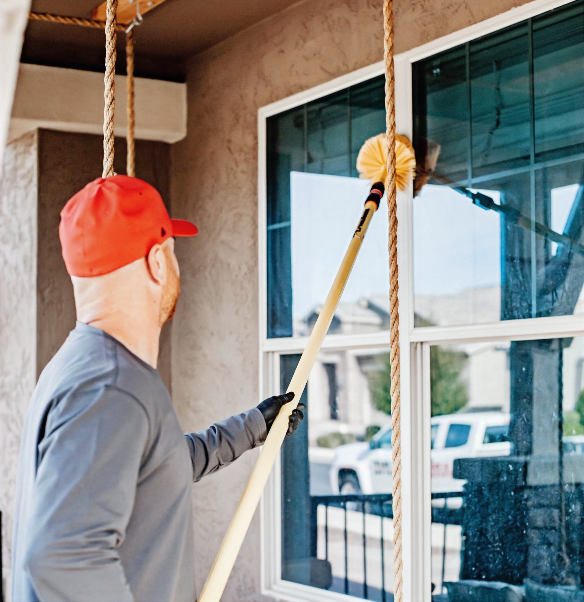 Technician removing spider webs from a home in Gilbert, AZ