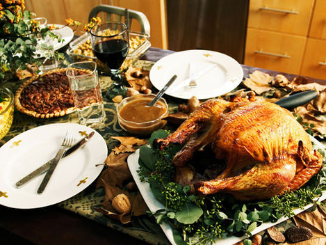 Holiday dinner table with roasted turkey and festive foods, illustrating concerns about holiday meals and maintaining weight-loss progress.