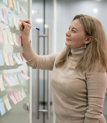 Mujer escribiendo sus ideas en notas adhesivas. Representa el módulo 3 del Método Sol "Transforma".