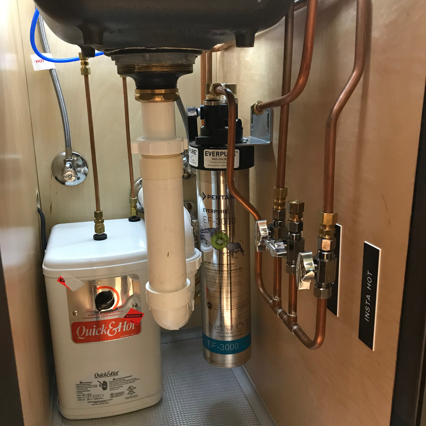 High-efficiency tankless water heater installation with integrated water filtration and professionally routed plumbing connections.
