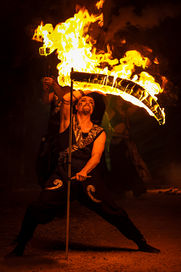 Un artiste de feu danse avec une faux enflammée à Paris