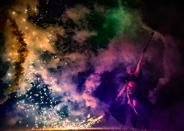 Une danseuse de feu avec un artifice pour le spectacle de feu en Bretagne