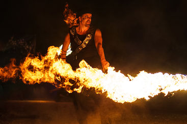 Un artiste de feu qui manipule une faux enflammée à Paris