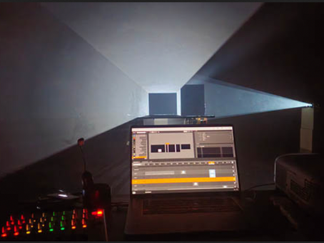 Installation spatiale et lumineuse vue depuis derrière un ordinateur.