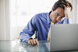Stressed businessman looking at laptop