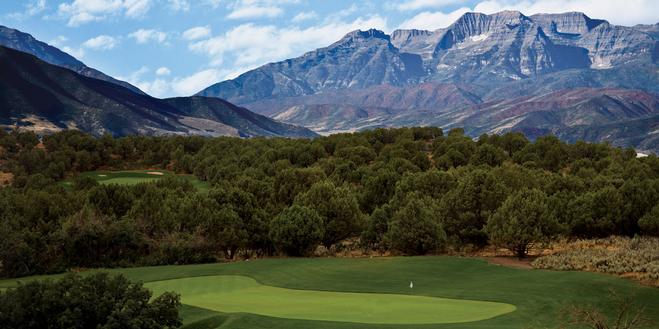 Scenic golf course green with mountain views.