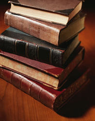Stack of leather-bound antique books on a table