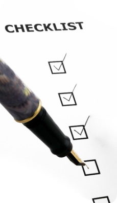 Hand using a fountain pen to mark a checklist.
