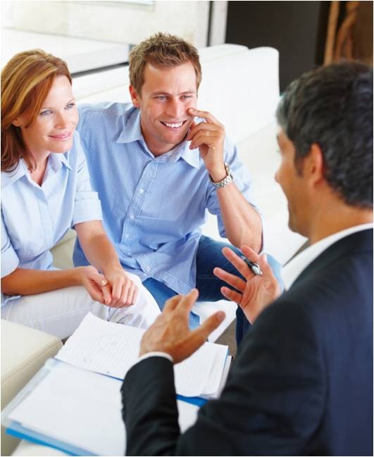 Smiling couple consulting with a professional advisor.