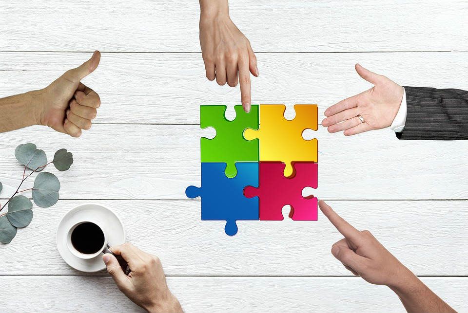 Hands pointing at a four-piece colorful puzzle.