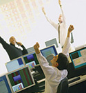 Traders cheering in a stock market office with monitors