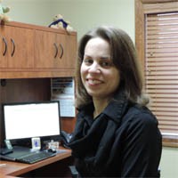 Portrait of Candace Shira at her office desk.