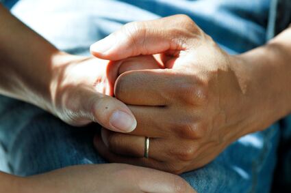 closeup of caregiver holding elderly hand