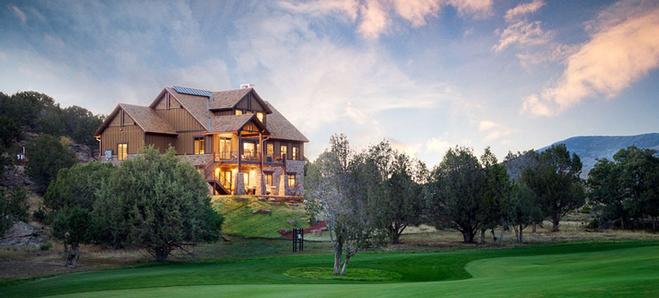 Large luxury home overlooking a green golf course landscape