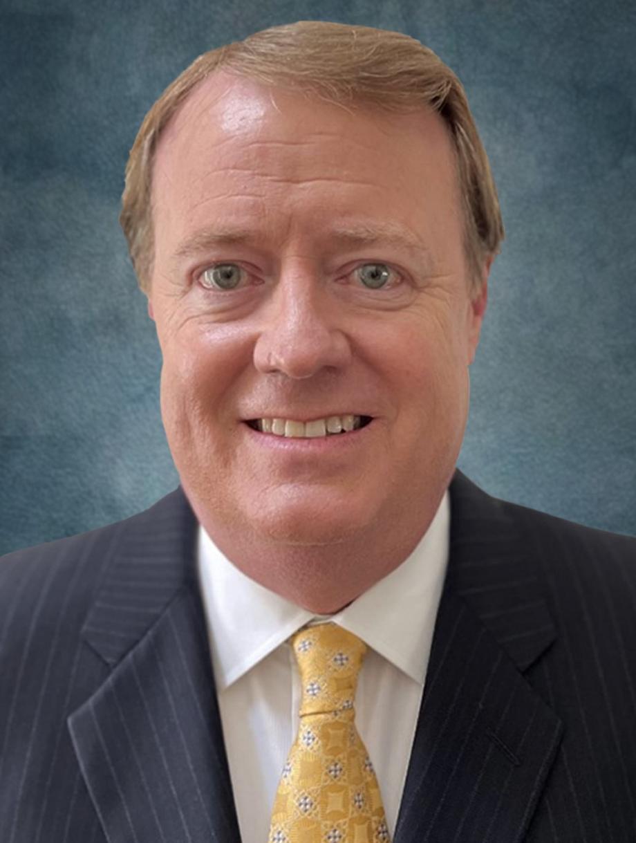 Smiling man in a suit and yellow tie representing leadership.
