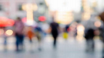 Blurred street scene with people walking in a city.