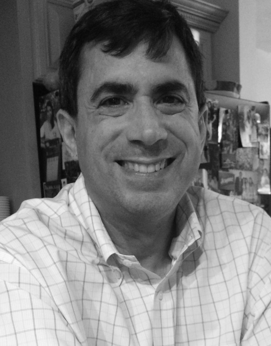 Smiling man wearing a checkered shirt at RPG Wealth Management.