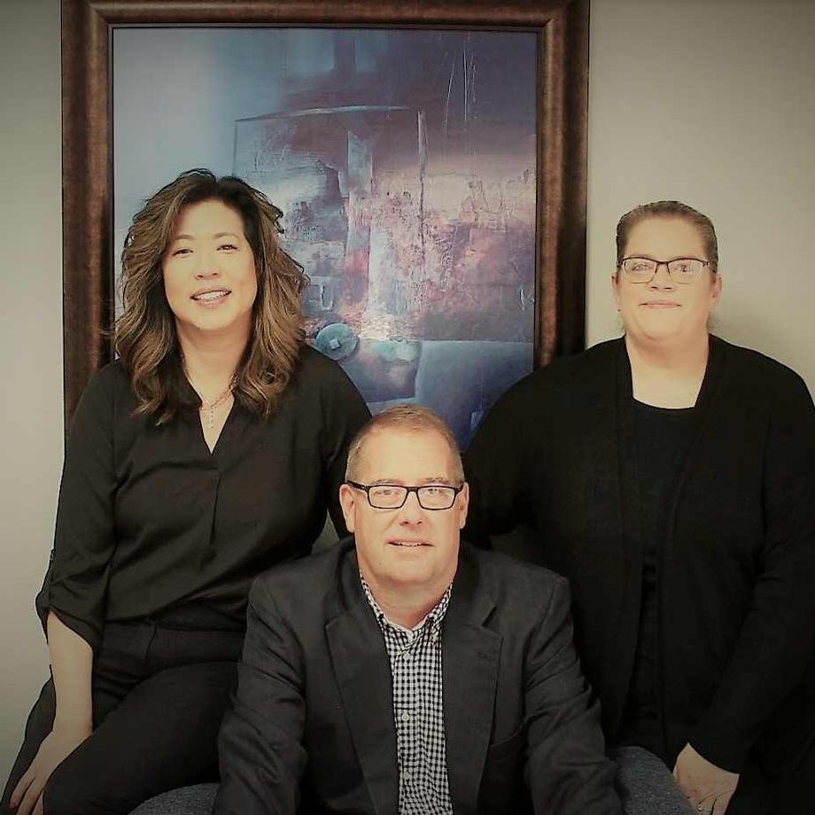 Three colleagues posing together for Our Story page