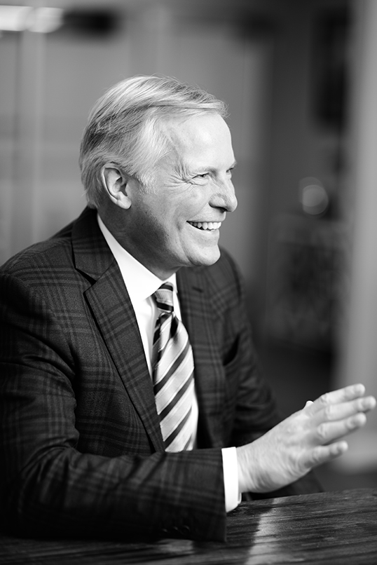 Smiling man in a suit gesturing during a conversation