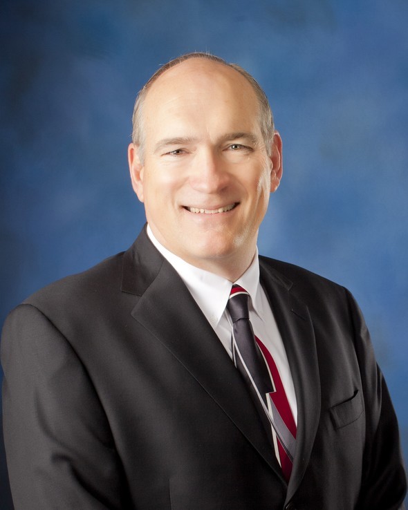 James Rodgers smiling in a suit and tie.