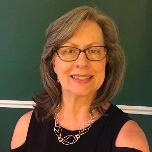 Smiling woman with glasses and necklace from our team