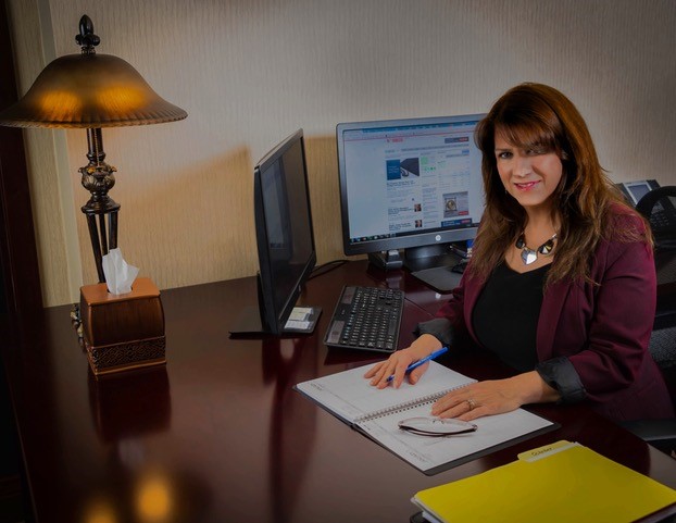 Woman at a desk with computer monitors during an office tour.