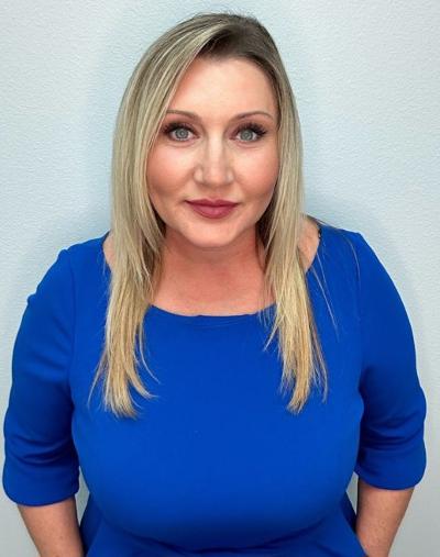 Portrait of a blonde woman in a blue dress.