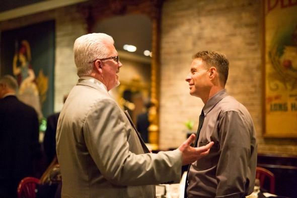 Two colleagues discussing mission and value at a networking event.