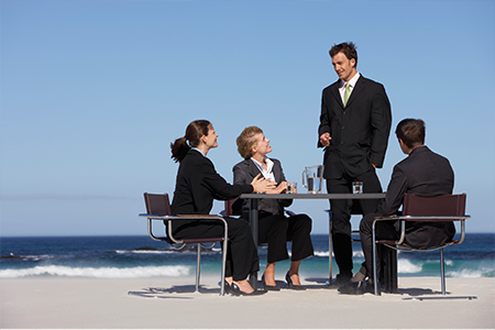 Business professionals having a meeting at the beach.