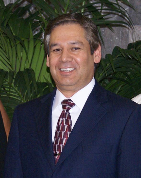 Smiling male associate in a suit with a patterned tie.