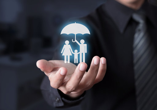Hand holding a glowing family under an umbrella.