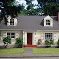 Small vacation home with white siding and a red door