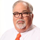 Professional headshot of a man with glasses and a goatee