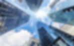 Modern glass skyscrapers against a sunny blue sky