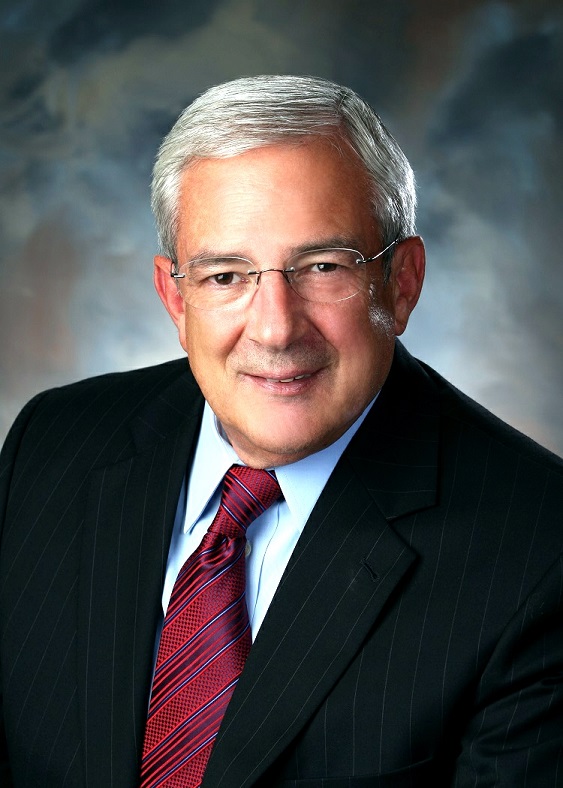 Professional headshot of a smiling man in a suit and tie