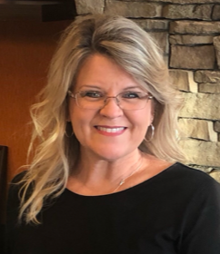 Smiling staff member with blonde hair and glasses