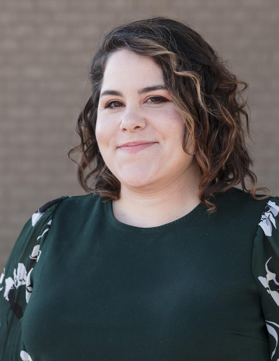 Smiling woman with wavy hair, member of our team