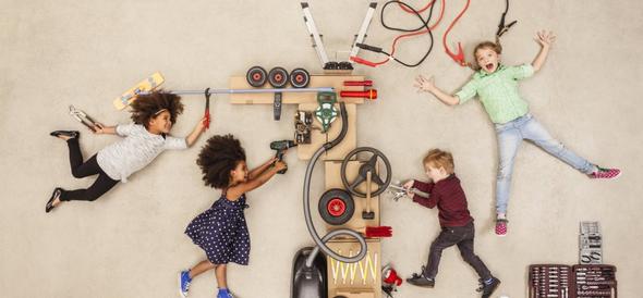 Children playing around a complex mechanical invention