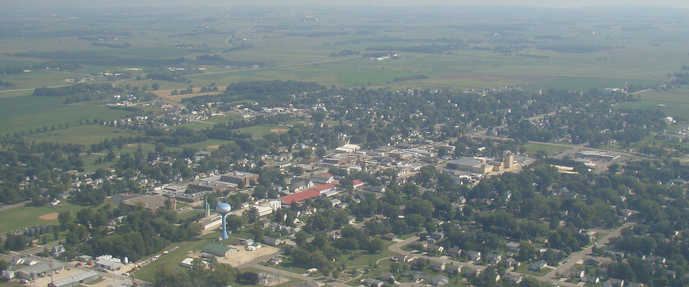 Aerial view of a small town surrounded by green fields