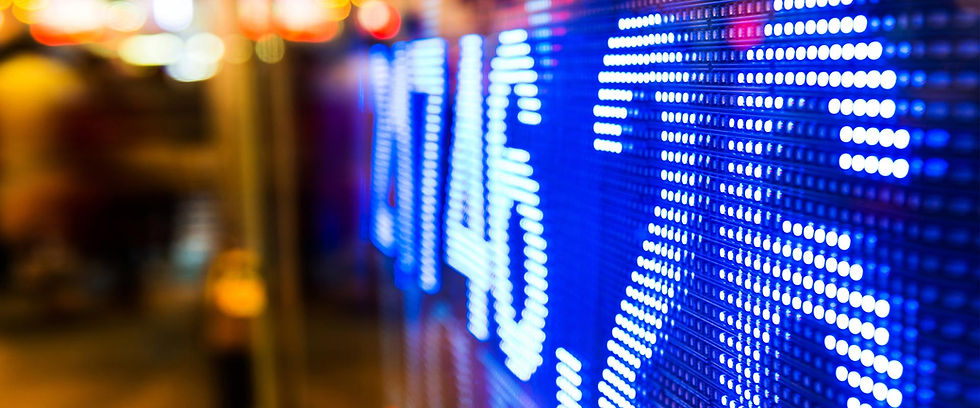 Close-up of a glowing blue stock market ticker board.