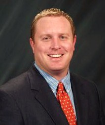 Smiling male associate in a suit and red tie