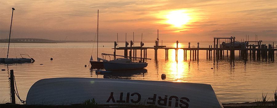 Sailboats at a dock in Surf City during sunset