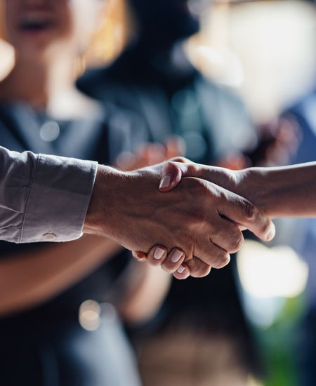 Close-up of two professionals shaking hands in agreement.