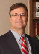 Smiling professional man in a suit and red striped tie
