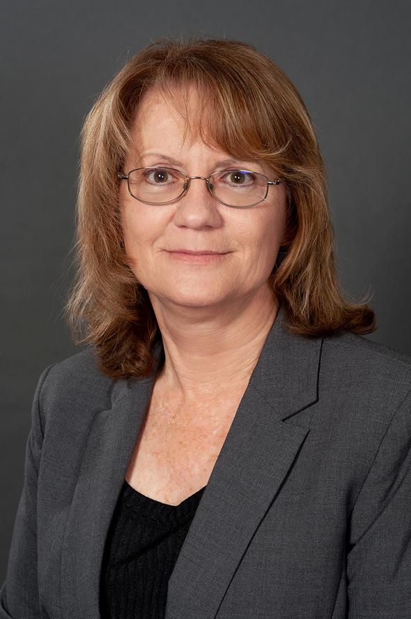 Shelley Guerra wearing glasses and a grey blazer.