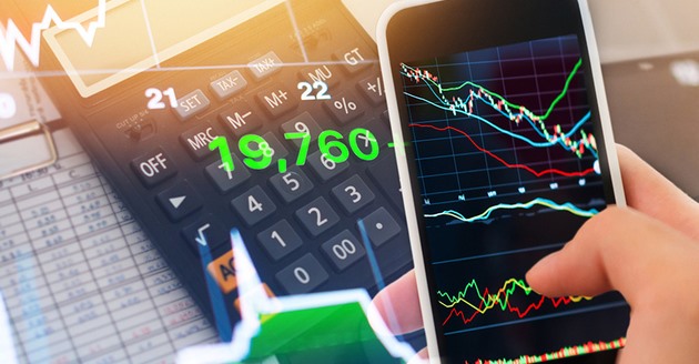 Smartphone displaying stock market charts next to a calculator.